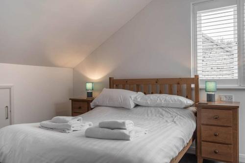 a bedroom with a white bed with towels on it at Seascape - Modern one bedroom, two storey annexe in Kent