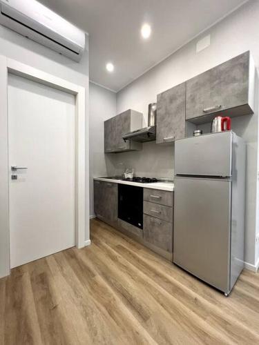une cuisine avec un réfrigérateur blanc et une porte dans l'établissement Grano - appartamento Lecce centro, à Lecce