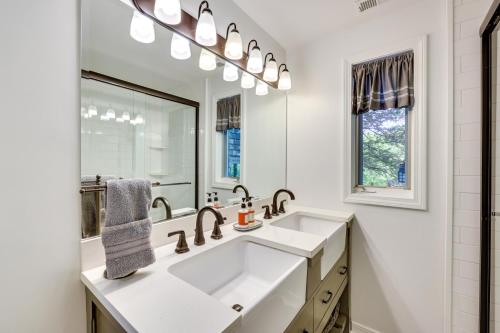 een witte badkamer met een wastafel en een spiegel bij Waterfront Eureka Springs Vacation Rental with Deck in Eureka Springs