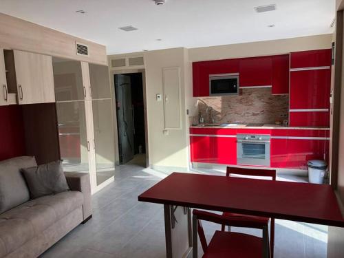 Il comprend un salon avec un canapé et une cuisine rouge. dans l'établissement LA FAVORITE - Centre de Cassis - Climatisation, à Cassis