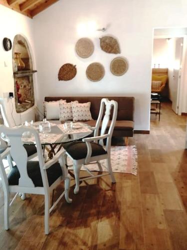 a dining room with a table and chairs and a couch at Ti Chôa - Casa da Mata in Angra do Heroísmo