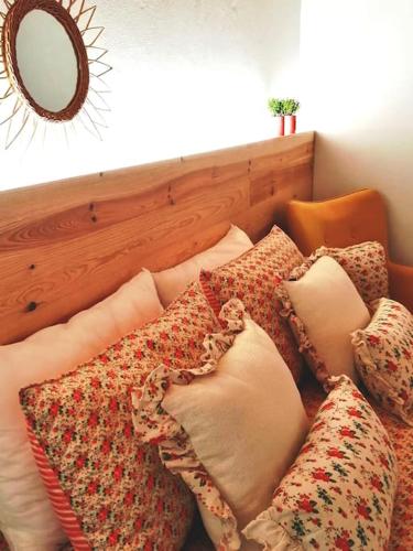 a pile of pillows sitting on a couch with a mirror at Ti Chôa - Casa da Mata in Angra do Heroísmo