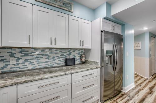 een keuken met witte kasten en een koelkast bij South Wind 902 in Myrtle Beach