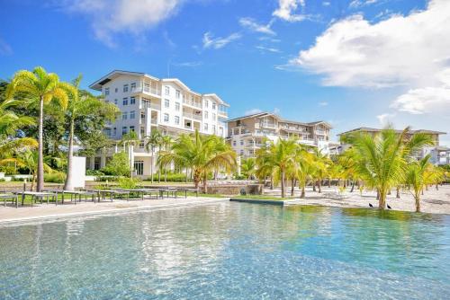 una piscina con palmeras frente a los apartamentos en condominio en Bristol Lake House - Private Pool - King Beds - Next to El Faro Beach Club en Boca de Río Hato