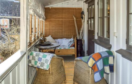 een veranda met 2 rieten stoelen en een tafel bij 3 Bedroom Beautiful Apartment In Gamle Fredrikstad in Vaterland
