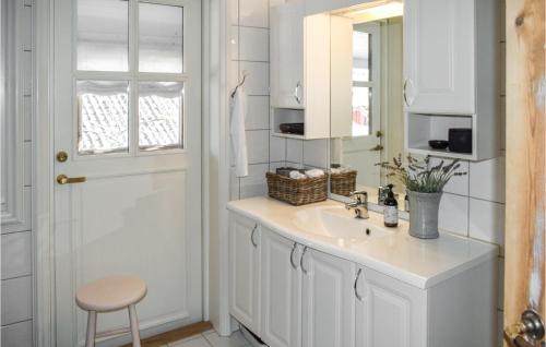 een witte badkamer met een wastafel en een spiegel bij 3 Bedroom Beautiful Apartment In Gamle Fredrikstad in Vaterland