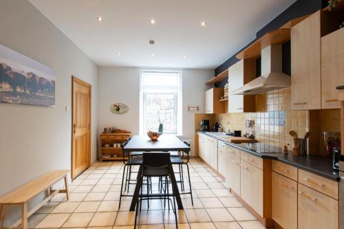 a kitchen with a table and some chairs in it at Maison spacieuse unifamiliale. Gîte La Clochette in Bastogne