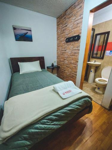 a bedroom with a bed and a bathroom with a toilet at Hotel El Molino in Facatativa