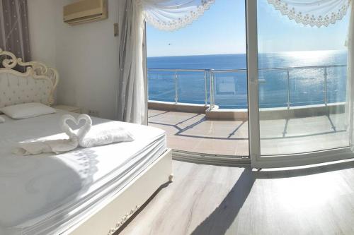 a bedroom with a view of the ocean from a balcony at Antalya Konyaaltı Plajında dublex GEMİ EV in Antalya