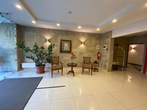 a lobby with chairs and a table in a building at Hotel Nicolás Temuco in Temuco