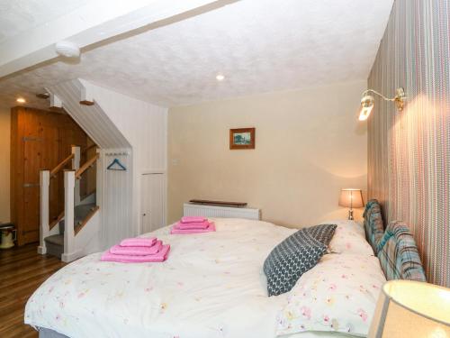 a bedroom with a large bed with pink towels on it at Hafod in Llanddeiniolen