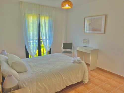 a bedroom with a bed and a window and a desk at Apartamento Ultreia - Estorde in Cee