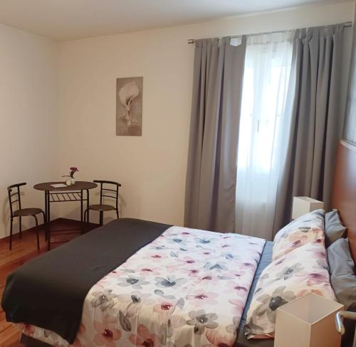 a bedroom with a bed and a table with chairs at Affittacamere La Loggia in Venzone