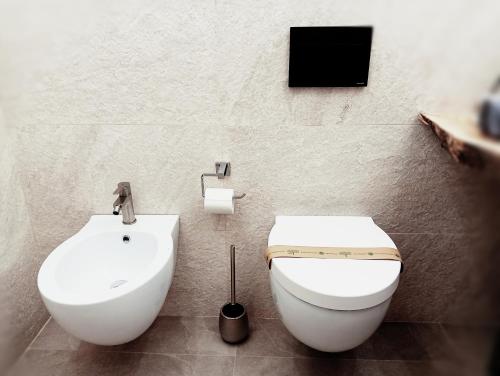 a bathroom with a toilet and a tv on the wall at La casa di SELLY 2 - A Due Metri Dal Mare- in Bergeggi