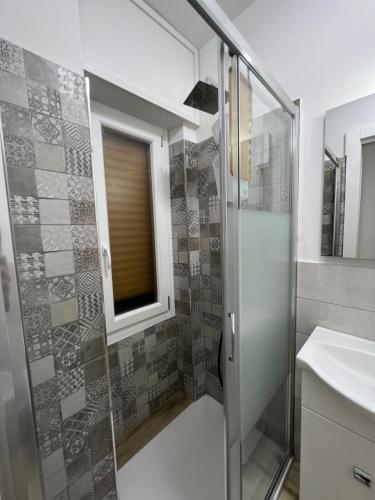 a bathroom with a glass shower and a sink at Alì Babà Rooms in La Spezia