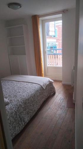 une chambre avec un lit et une grande fenêtre dans l'établissement Le Chalet, à Mers-les-Bains