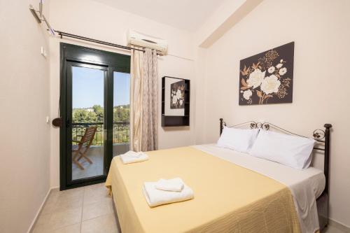 a bedroom with a large bed and a window at Villa Aliki in Pefkohori