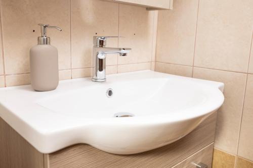 a white sink in a bathroom with a soap dispenser at Villa Aliki in Pefkohori