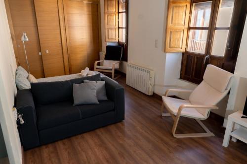 sala de estar con sofá y 2 sillas en Puerta Real Luxury Apartments Granada, en Granada