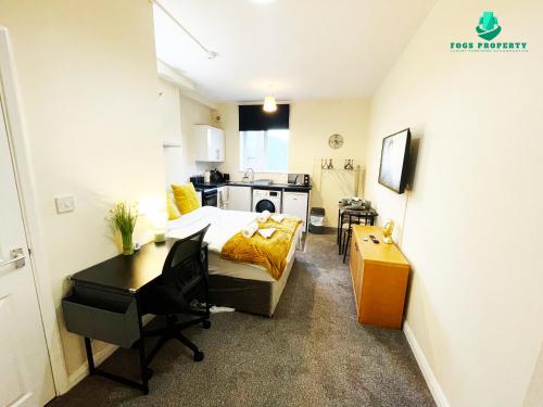 a room with a bed and a desk and a kitchen at Fogs Property - Darlington City Apartments in Darlington