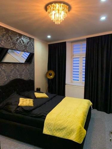 um quarto com uma cama grande e um cobertor amarelo em Apartament Franciszkanska 21 em Przemyśl
