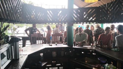 a group of people sitting at a bar at Tortugal Boutique River Lodge in Rio Dulce