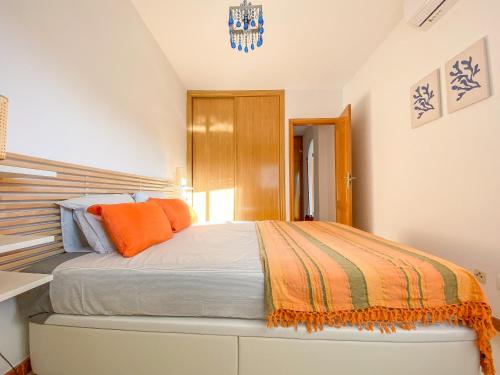 Un dormitorio con una cama grande con almohadas naranjas. en Casa Azul - San Luis de Sabinillas, en San Luis de Sabinillas
