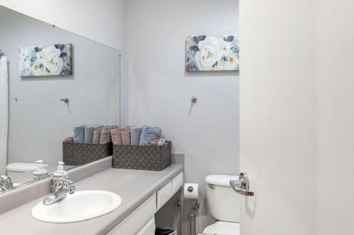 a bathroom with a sink and a mirror and a toilet at Greely Gaslamp - Loft W Parking & 4 Beds #201 in San Diego