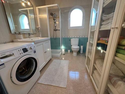 a bathroom with a washing machine and a toilet at Beautiful Villa Close to Xabia & Moraira in Benitachell