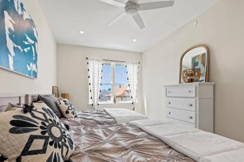 a bedroom with a bed and a dresser and a mirror at Oasis by Seaport Stays in Wildwood