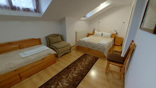 sypialnia z 2 łóżkami i krzesłem w obiekcie Vitosha Guest House w mieście Devín