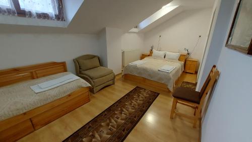 a bedroom with two beds and a chair in it at Vitosha Guest House in Devin