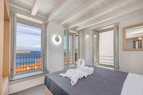 哈爾基的住宿－Chalki Sunrise Suites，一间卧室设有一张享有海景的床。