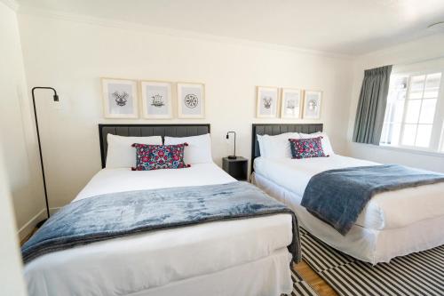two beds in a room with white walls at Viking Inn in Solvang