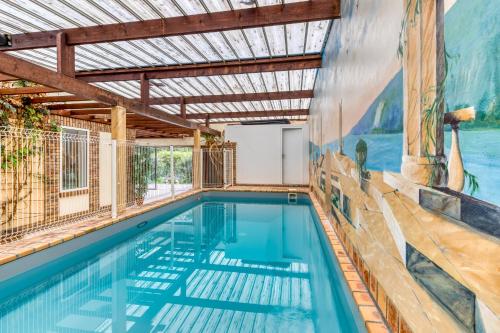 - une piscine dans une maison ornée d'une peinture murale dans l'établissement Relax en Normandie, à Lillebonne