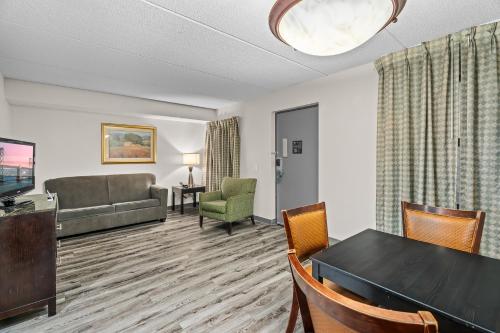 a living room with a table and chairs and a couch at Quality Inn & Suites Mall of America - MSP Airport in Bloomington
