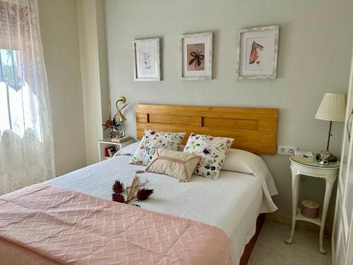 デニアにあるApartamento con encanto cerca del marのベッドルーム1室(木製ヘッドボードと枕付きのベッド1台付)