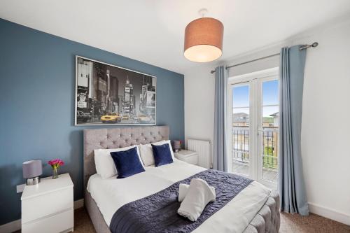 sypialnia z łóżkiem z niebieskimi ścianami i oknem w obiekcie Luxnightzz - Clarendon Heights - Stylish Two-Bedroom Apartment w mieście Colchester