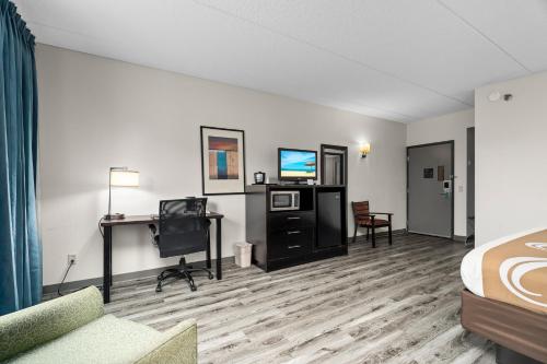 a hotel room with a bed and a flat screen tv at Quality Inn & Suites Mall of America - MSP Airport in Bloomington
