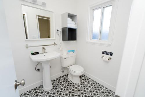 a white bathroom with a toilet and a sink at Viking Inn in Solvang