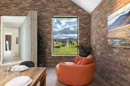 a living room with an orange chair and a table at Countryside Escape Arrowtown in Arrowtown