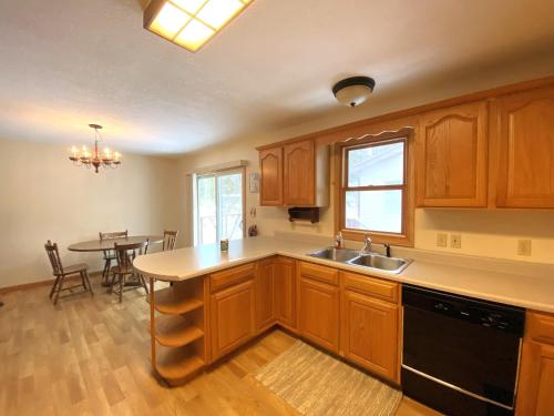 a kitchen with wooden cabinets and a dining table at North Country Retreat in Saint Ignace