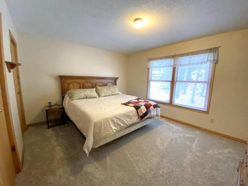 a bedroom with a large bed and a window at North Country Retreat in Saint Ignace