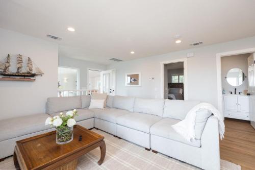 a living room with a white couch and a table at Bright and airy beach vacation spot- perfect for families and ocean views in Moss Beach