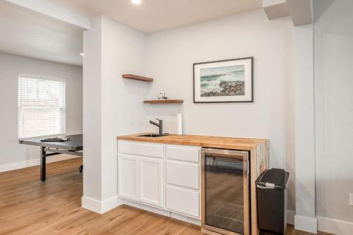 a kitchen with a sink and a desk in a room at Bright and airy beach vacation spot- perfect for families and ocean views in Moss Beach