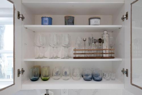 a cabinet filled with glasses on shelves in a kitchen at Bright and airy beach vacation spot- perfect for families and ocean views in Moss Beach