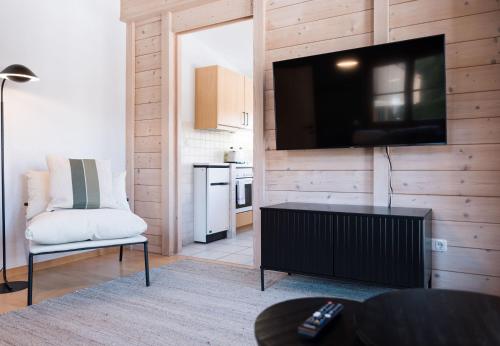 a living room with a flat screen tv on a wooden wall at Haus Luisa in Schruns