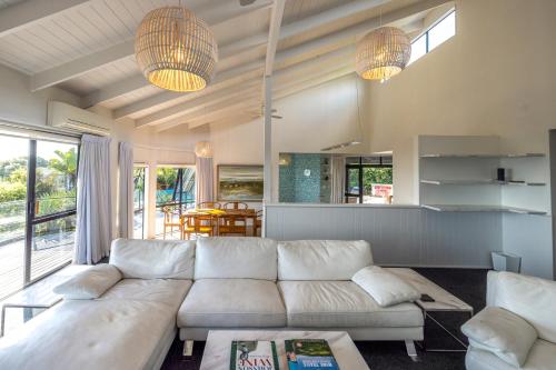 a living room with a white couch and two lights at Villa Valmont - Stay Waiheke in Palm Beach