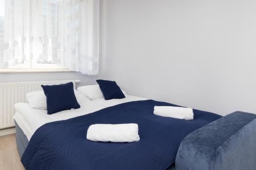 a bedroom with two beds with blue and white pillows at Gdańsk Aleja Jana Pawła II Apartment with Parking and Balcony by Renters in Gdańsk