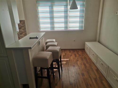 a room with a bar with chairs and a window at ZOJA City Centre Apartments in Kavadarci